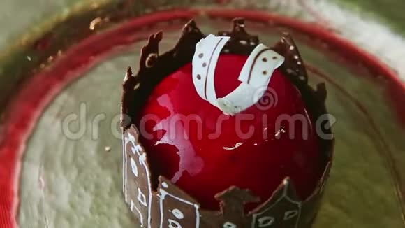 从红色釉面甜点慢慢放大巧克力城堡旋转在金色盘子上视频的预览图