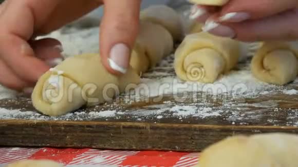 一排生牛角面包自制甜点果酱家里厨房的面团女性手拿一个羊角面包视频的预览图