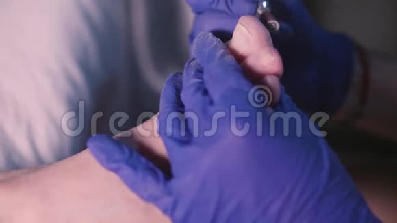 双手合拢戴蓝色手套用美甲机打磨指甲周围干燥的皮肤视频的预览图