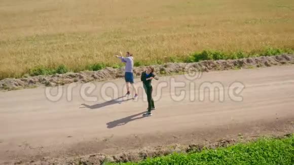 一个年轻人和一个穿着运动服的女孩子在沿着碎石路慢跑之前正在身体视频的预览图