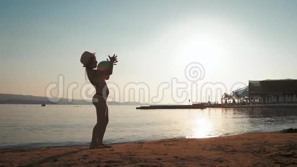 小女孩在日落时在海滩上玩五颜六色的球享受一个可爱的假期视频的预览图