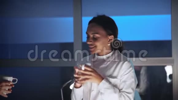 接近非裔美国女工程师在实验室里和一杯饮料讨论什么视频的预览图