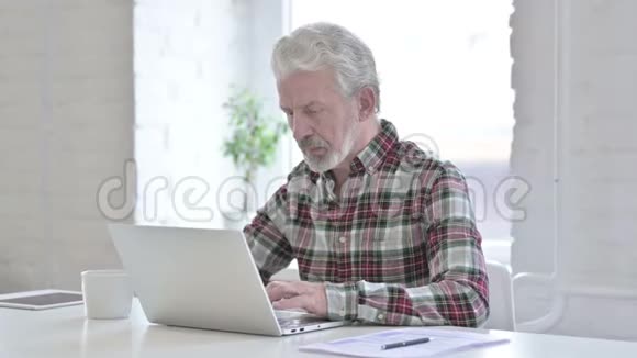 勤劳的休闲老人喝咖啡工作视频的预览图