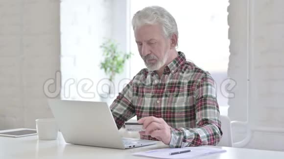 专注的休闲老人在笔记本电脑上在线付款视频的预览图