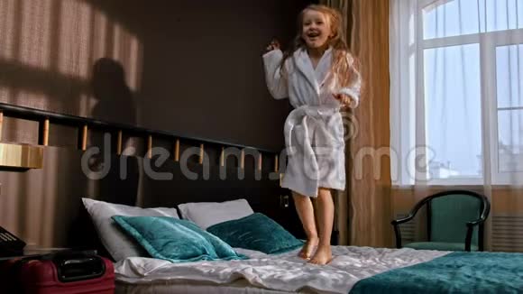 一个留着长发的小女孩在旅馆房间的床上跳视频的预览图