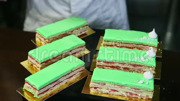 用白色撞碎的bizet装饰绿色釉蛋糕部分的过程视频的预览图