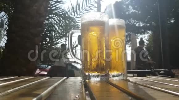 一杯热气腾腾的冰镇啤酒放在夏日咖啡馆的桌上视频的预览图