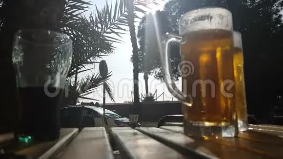 一杯热气腾腾的冰镇啤酒放在夏日咖啡馆的桌上视频的预览图