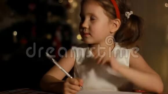 甜蜜的白种人孩子正在给房间里的圣诞老人写一封信为圣诞节做装饰为节日做准备视频的预览图