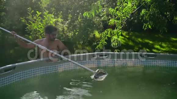 戴眼镜的印度男人清洁花园框架池视频的预览图