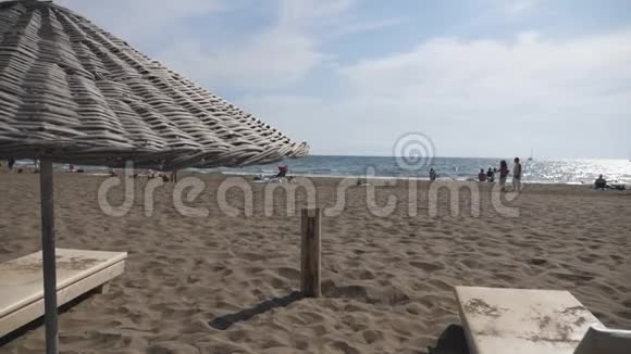 夏日带草太阳伞的海景和沙滩美景舒适的地方有躺椅视频的预览图