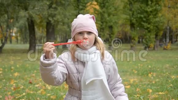 有趣可爱的小女孩吹肥皂泡的肖像视频的预览图