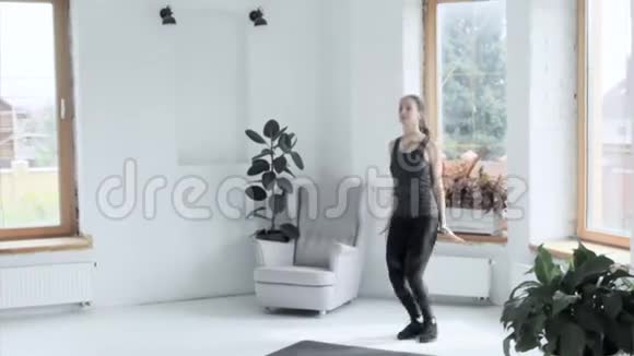 年轻健康的黑发美女在家锻炼女孩跳起来拍手视频的预览图