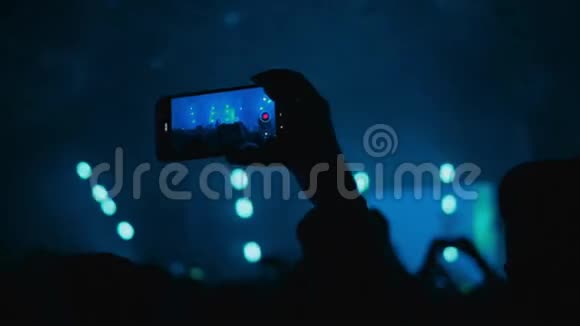 人们在音乐音乐会上玩得很开心一个女人在她的智能手机上记录了一段表演的视频俱乐部气氛视频的预览图