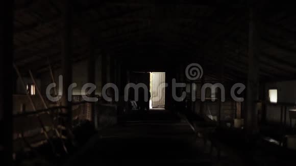 在一个农场棚子敞开的门的背景下男人的黑暗轮廓视频的预览图