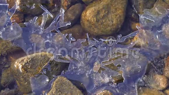在冰封的海岸上用石头底部覆盖脆弱的冰层视频的预览图
