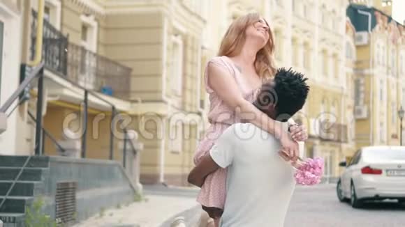 年轻的黑人男子在街上散步时把女友抱在怀里视频的预览图