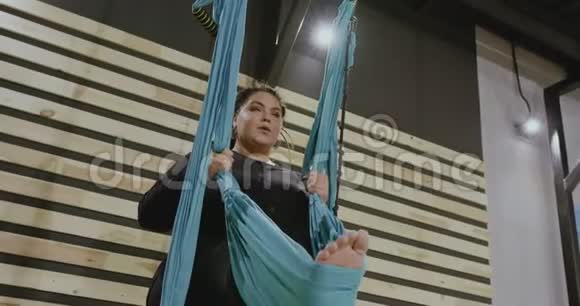 很胖的身体积极的女人在吊床上做伸展运动站在前台积极向上开放心态视频的预览图
