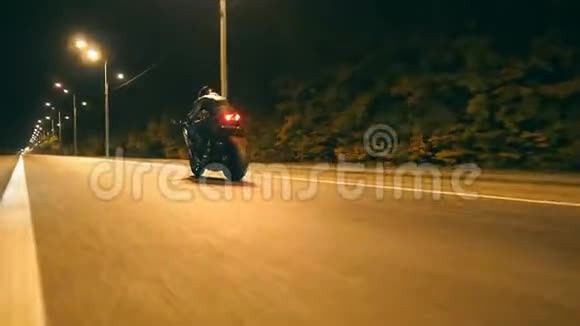 男人骑着现代运动摩托车在夜城街摩托车手在空路上驾驶摩托车盖盖视频的预览图