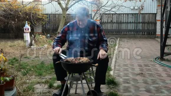 老人在自家后院烧烤时吃肉人的现实生活观念中期计划视频的预览图