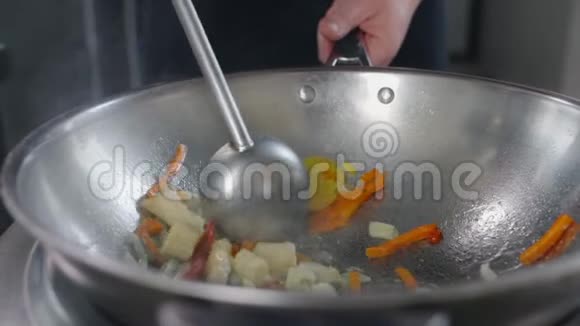 厨师用慢动作的热锅炒菜和鱼煮亚洲锅在热锅里搅拌中国快餐视频的预览图