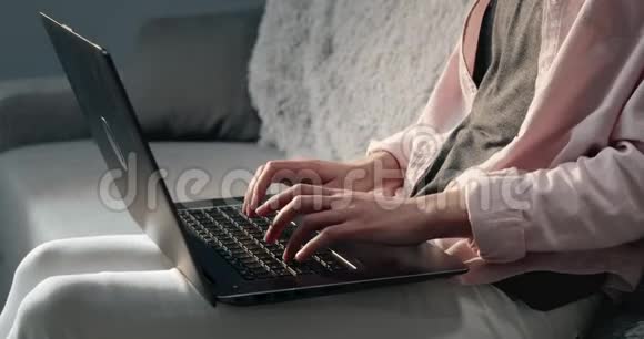 靠近坐在沙发上拿着笔记本电脑的年轻女人视频的预览图