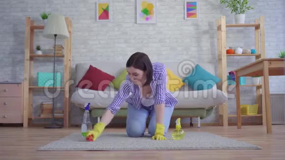 年轻的女家庭主妇打扫一个男人走路的地毯视频的预览图