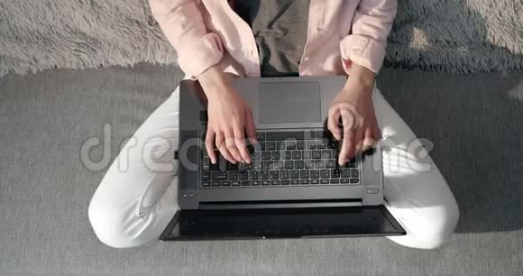 年轻女士坐在沙发上在笔记本电脑上打字视频的预览图