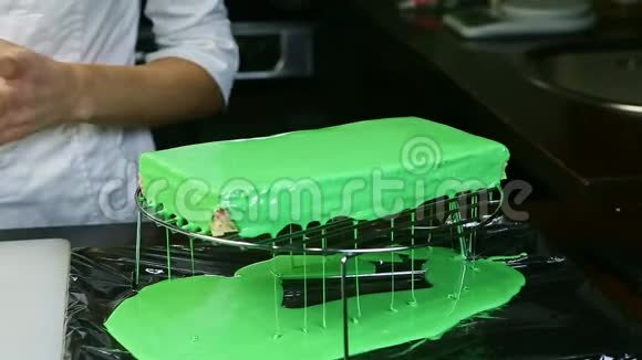 绿色镜面釉从金属支架上的长方形蛋糕上流下来视频的预览图