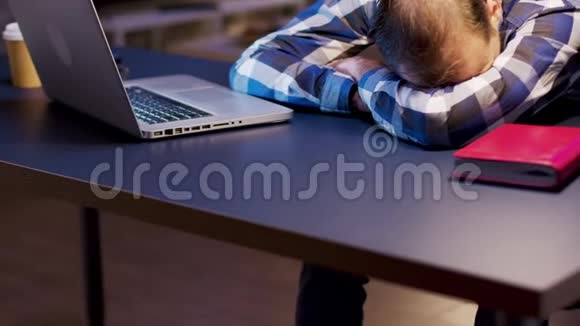 工作过度的企业家躺在家里办公室的桌子上睡觉视频的预览图