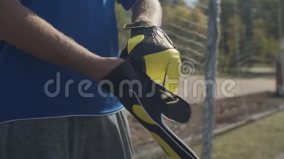 足球守门员在户外调整守门员手套视频的预览图