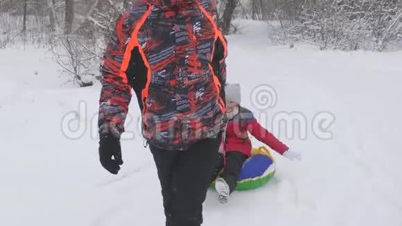 另一个在冬天的公园里和他的女儿玩孩子骑在吐宾快乐的爸爸在雪道上载着一个孩子视频的预览图