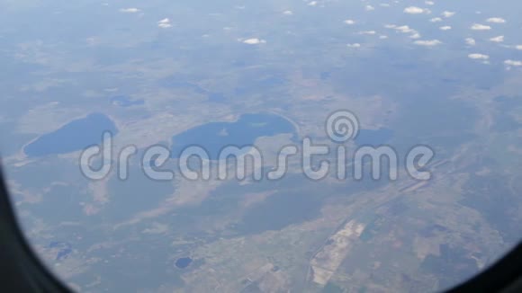 飞机从舷窗飞过沙漠田野和湖泊视频的预览图