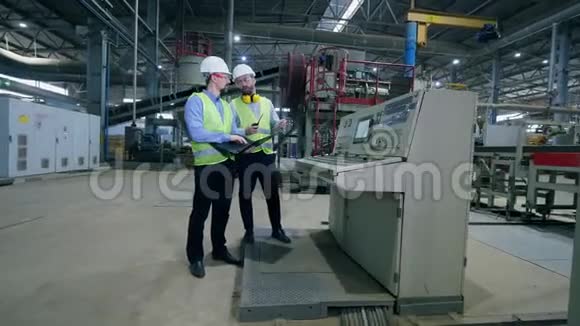 一家现代化工厂的男工程师工人们在一家现代工业工厂检查工厂机器视频的预览图