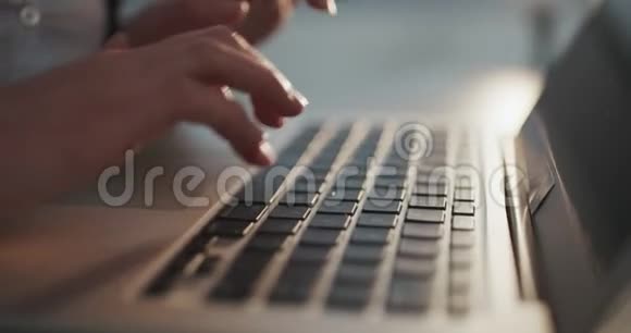 女性手在笔记本电脑键盘上输入触摸板没有脸的女人坐在沙发上自由工作在家写视频的预览图