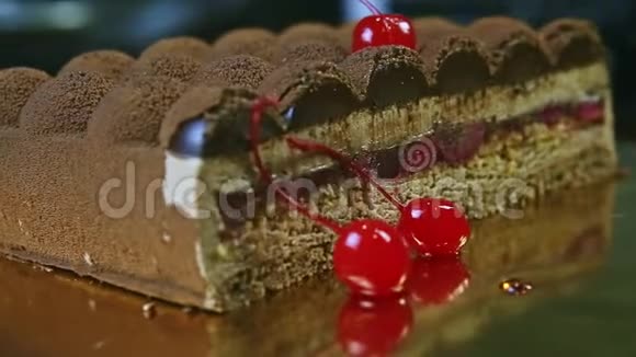 特写手旋转盘一半巧克力奶油蛋糕与樱桃夹层视频的预览图