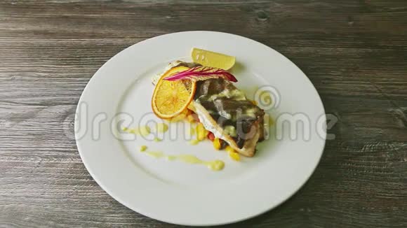 在精心装饰的烤海鱼上放大然后在盘子上旋转视频的预览图