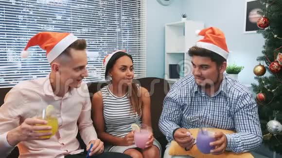 三个戴着圣诞帽的朋友一起欢呼吹吹派对口哨视频的预览图