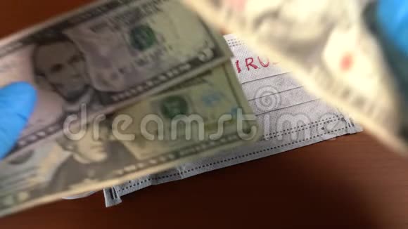 手上拿着美元的钞票盖着一个面具上面写着冠状病毒视频的预览图