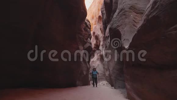 旅游徒步旅行在深槽峡谷干燥河床与橙色平滑岩石视频的预览图