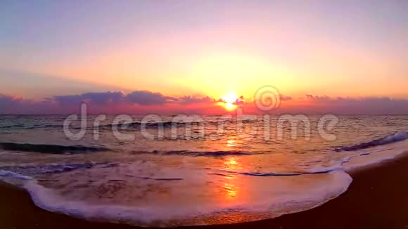 海浪拍打沙滩在令人惊叹的橙色温暖的傍晚日落海滨景观稳定的视野视频的预览图