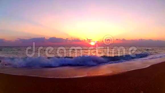 海浪拍打在沙滩上完美的橙色温暖的黄昏日落在海边的风景稳定的视野视频的预览图