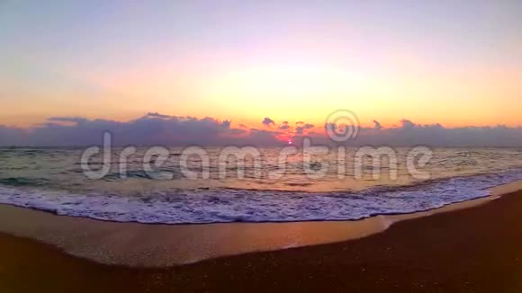 海浪拍打在沙滩上壮观的橙色温暖的黄昏日落在海滨景观稳定的视野视频的预览图