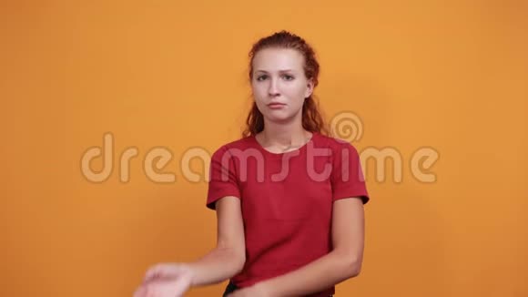 穿红衬衫的迷人的无聊的年轻女士手挽着下巴视频的预览图