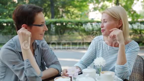 快乐的成熟女人在户外咖啡馆聊天在餐桌上尽情享受视频的预览图