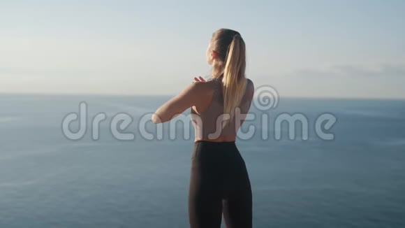 女士在日出时户外健身观海景慢动作视频的预览图