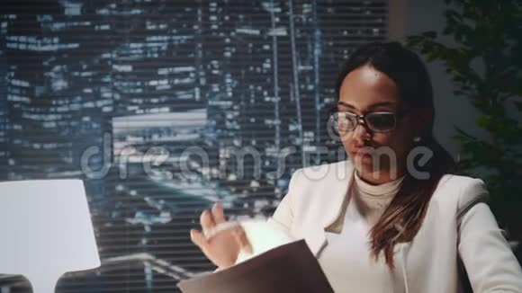 非裔美国商业女性戴眼镜阅读杜库门视频的预览图