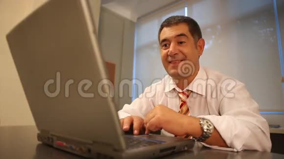 成功的商人在办公室里使用笔记本电脑视频的预览图