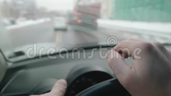 驾驶时两个司机的手都在方向盘上汽车驶近十字路口透过模糊的观点视频的预览图