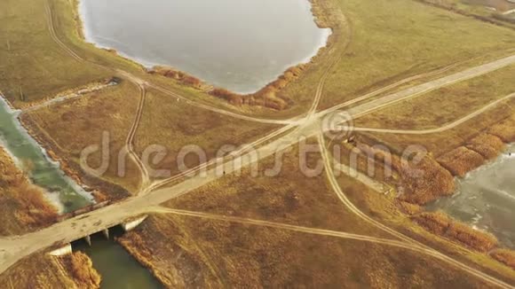 空中观景深秋人们骑自行车在湖边的乡村公路上无人驾驶飞机的景色鸟的视野视频的预览图